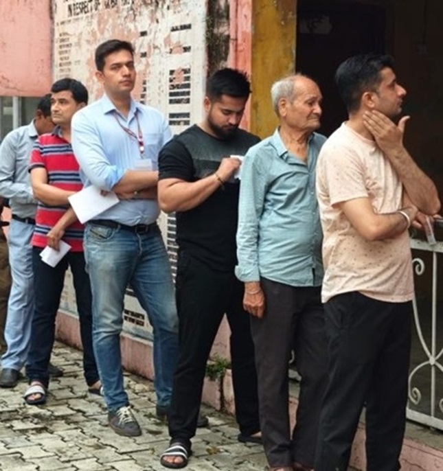 Rakesh Minhas, RO, Udhampur Lok Sabha constituency casts his vote after standing in a queue 